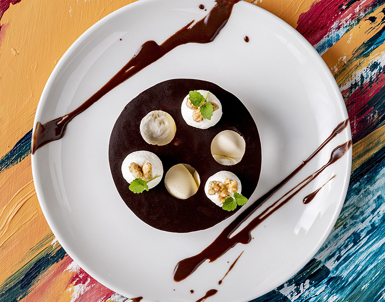 Sauce au chocolat, crème fouettée, glace à la vanille, croquant au caramel salé et Atsina Cress