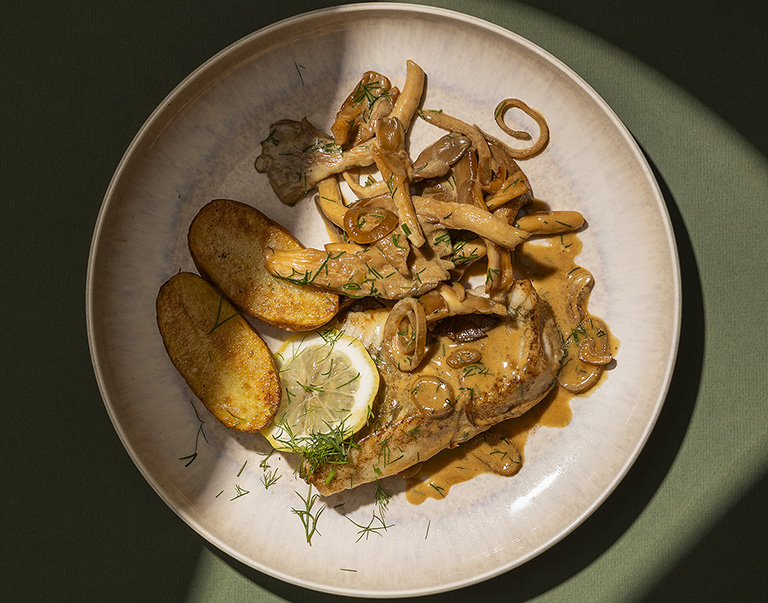 Pleurotes crémeuses mijotées au vin blanc et à la crème fraîche, accompagnées de succulents filets de plie au beurre de sauge et de citron. 