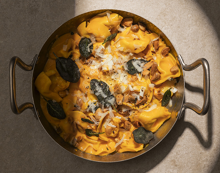 Tortelloni avec une sauce crémeuse au potiron, finis avec des amandes croquantes, de la sauge et un généreux saupoudrage de fromage pecorino.