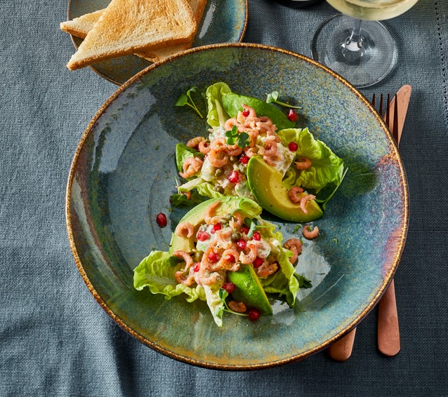 Kropsla gevuld met Noordzeevissalade, gegarneerd met avocado, Hollandse garnalen, granaatappel en toast.